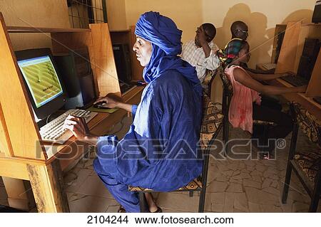 Picture - Niger, Sahara Desert, Agadez Region, Tuareg man surfing net at internet cafe; Agadez. Fotosearch