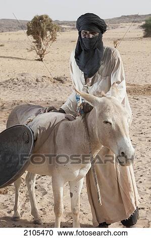 Stock Image - Niger, Sahara Desert, Agadez Region, Tuareg man with donkey; Agadez. Fotosearch