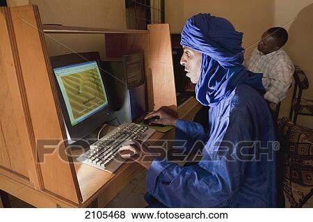 Niger, Sahara Desert, Agadez Region, Tuareg man surfing net at internet cafe; Agadez View Large Photo Image Stock Photo - Niger, Sahara Desert, Agadez Region, Tuareg man surfing net at internet cafe; Agadez. Fotosearch