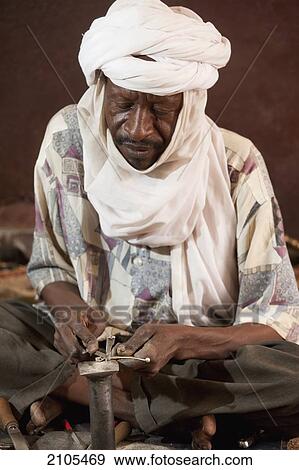 Niger, Sahara Desert, Agadez Region, Tuareg craftman making famous Cross of Agade; Agadez View Large Photo Image Stock Photo - Niger, Sahara Desert, Agadez Region, Tuareg craftman making famous Cross of Agade; Agadez. Fotosearch