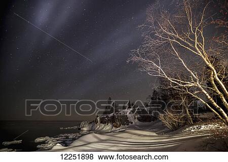 Stock Photo - Night sky with stars and Lake Superior in winter; Grand Portage, Minnesota, United States of America. Fotosearch