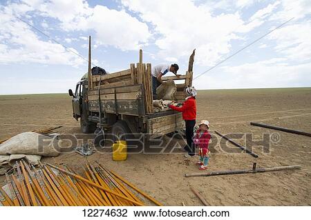 Stock Image - Nomad family dismantling a Mongolian ger (yurt) and loading it into a truck, Gobi Gurvansaikhan National Park,? mnÃƒÆ’Ã‚Â·govi Province, Mongolia. Fotosearch
