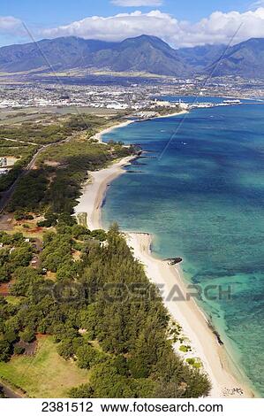 Stock Image - North shore of Maui looking toward, Kahului, Wailuku and West Maui Mountains, with Kanaha Beach Park in foreground; Maui, Hawaii, United States of America. Fotosearch