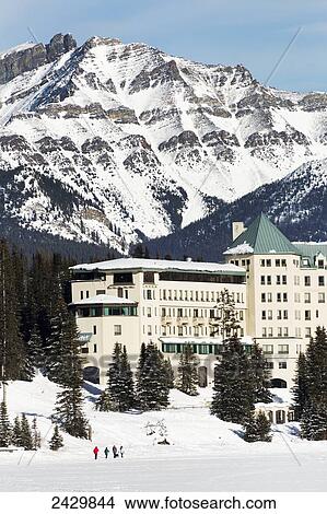 Picture - North side of the Chateau Lake Louise with snow covered lake and snow covered mountain in the background and blue sky; Lake Louise, Alberta, Canada. Fotosearch