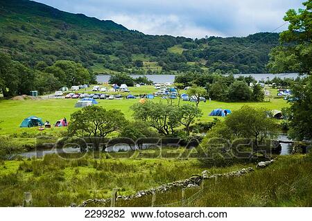 Stock Image - North Wales. UK, Snowdonia National Park, Nantgwynant, river and lake; Llyn Gwynant Campsite, surrounded by hillsides, Colorful tents & caravans in the valley. Fotosearch