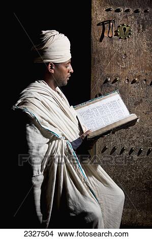 Northen Ethiopia, Ethiopian Orthodox priest reading bible in Yemrehanna Krestos Church; Lalibela View Large Photo Image Picture - Northen Ethiopia, Ethiopian Orthodox priest reading bible in Yemrehanna Krestos Church; Lalibela. Fotosearch