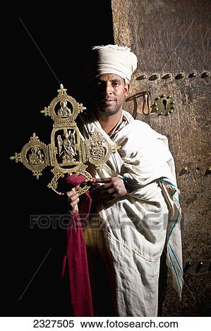 Northen Ethiopia, Ethiopian Orthodox priest holding traditional cross in Yemrehanna Krestos Church; Lalibela View Large Photo Image Stock Photography - Northen Ethiopia, Ethiopian Orthodox priest holding traditional cross in Yemrehanna Krestos Church; Lalibela. Fotosearch
