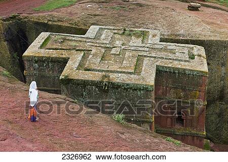 Stock Image - Northern Ethiopia, Ethiopian Orthodox pilgrim contemplating the famous Bet Giyorgis; Lalibela. Fotosearch