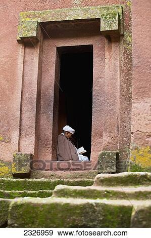 Stock Photo - Northern Ethiopia, Ethiopian Orthodox priest reading the Bible on one of churches side doorways; Lalibela. Fotosearch