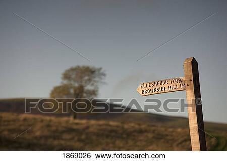 Stock Photograph - Northumberland, England; A Wooden Road Sign On A Post. Fotosearch