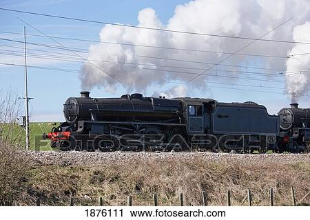 Stock Image - Northumberland, England; Steam From A Train As It Moves Along The Tracks. Fotosearch