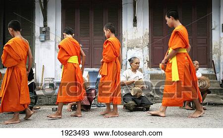Stock Image - Novice Monks Collecting Food Donations, Luang Prabang, Northern Laos. Fotosearch