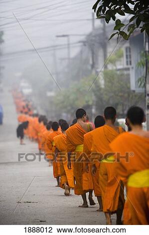 Stock Image - Novice Monks Out Collecting Alms At Dawn.. Fotosearch