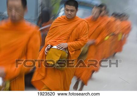 Stock Image - Novice Monks Out Collecting Alms At Dawn, Luang Prabang, Northern Laos (Unesco World Heritage Site). Fotosearch