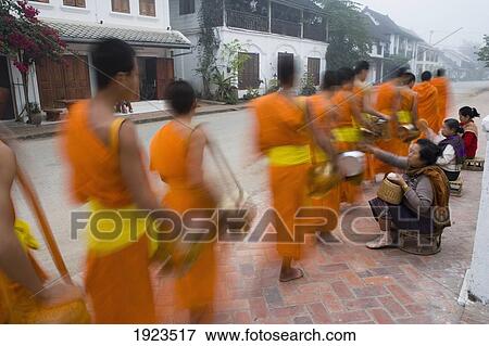 Novice Monks Out Collecting Alms At Dawn, Luang Prabang, Northern Laos (Unesco World Heritage Site) View Large Photo Image Stock Photo - Novice Monks Out Collecting Alms At Dawn, Luang Prabang, Northern Laos (Unesco World Heritage Site). Fotosearch