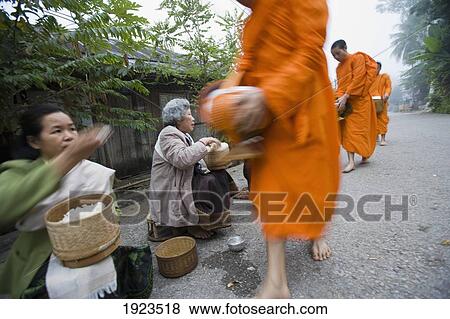 Novice Monks Out Collecting Alms At Dawn, Luang Prabang, Northern Laos (Unesco World Heritage Site) View Large Photo Image Stock Photo - Novice Monks Out Collecting Alms At Dawn, Luang Prabang, Northern Laos (Unesco World Heritage Site). Fotosearch