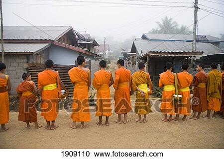 Novice Monks Out In Early Morning Collecting Alms At Wat Naluang, Luang Prabang, Northern Laos View Large Photo Image Stock Image - Novice Monks Out In Early Morning Collecting Alms At Wat Naluang, Luang Prabang, Northern Laos. Fotosearch
