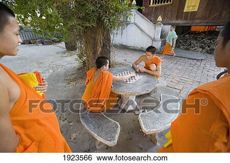 Stock Photograph - Novice Monks Relaxing Playing Checkers, Luang Prabang, Northern Laos. Fotosearch