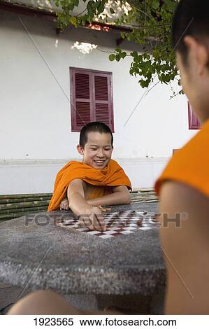 Stock Photography - Novice Monks Relaxing Playing Chess. Fotosearch