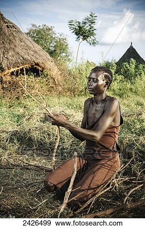 Stock Photo - Nuer woman preparing firewood, near Gambella, Western Ethiopia; Ethiopia. Fotosearch