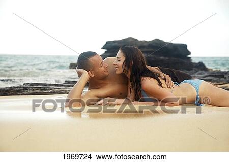 Picture - Oahu, Hawaii, Young Couple Laying On Sand.. Fotosearch