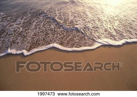 Stock Image - Ocean Shoreline Water On The Sand, Texture And Motion, Sunset Reflections A32C. Fotosearch