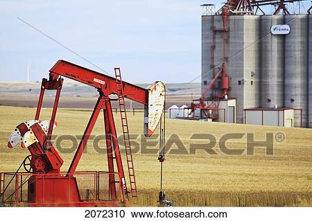 Oil Well Pump Jack, And Prairie Wheat Field. Inland Grain Terminal In The Background. Swift Current, Saskatchewan, Canada. View Large Photo Image Stock Image - Oil Well Pump Jack, And Prairie Wheat Field. Inland Grain Terminal In The Background. Swift Current, Saskatchewan, Canada.. Fotosearch