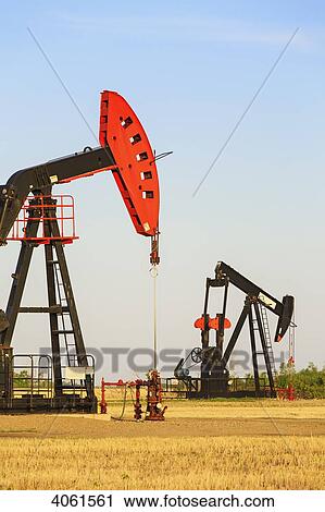 Stock Image - Oil well pump jacks at Bakken Oil Field near Estevan; Saskatchewan, Canada. Fotosearch