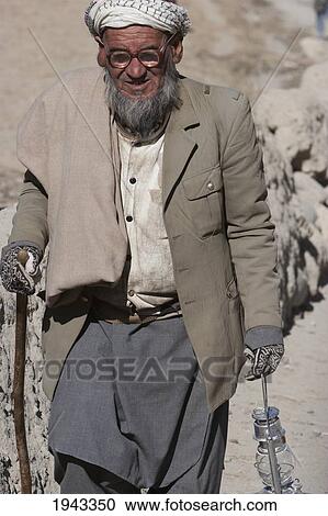 Old Afghan Man Holding A Lamp At The Bazaar In Bamiyan, Bamian Province, Afghanistan View Large Photo Image Stock Image - Old Afghan Man Holding A Lamp At The Bazaar In Bamiyan, Bamian Province, Afghanistan. Fotosearch