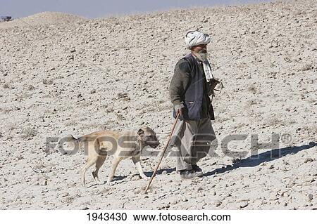 Stock Image - Old Afghan Shepherd With His Dog In The Outskirts Of Kabul,, Afghanistan. Fotosearch