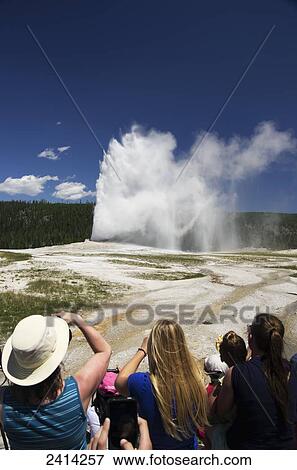 Old Faithful blows as tourists take photos of the geyser, Yellowstone National Park; Wyoming, United States of America View Large Photo Image Stock Photo - Old Faithful blows as tourists take photos of the geyser, Yellowstone National Park; Wyoming, United States of America. Fotosearch