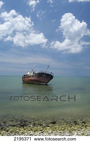 Stock Image - Old Fishing Boat Run Aground In Shallow Water, Black River, Jamaica.. Fotosearch