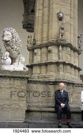 Stock Image - Old Man Sitting In Front Of Pillar. Fotosearch