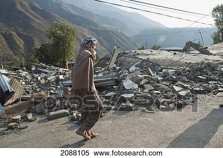 Stock Photography - Old Man Walking By The Bazaar Destroyed By The 8 October 2005 Earthquake, Chakothi, Azad Kashmir, Pakistan. Fotosearch