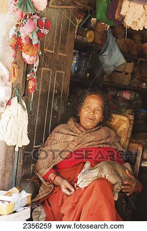 Old Newar woman dressed in traditional clothes holds her cat inside her shop doorway; Bhaktapur, Nepal View Large Photo Image Stock Photo - Old Newar woman dressed in traditional clothes holds her cat inside her shop doorway; Bhaktapur, Nepal. Fotosearch