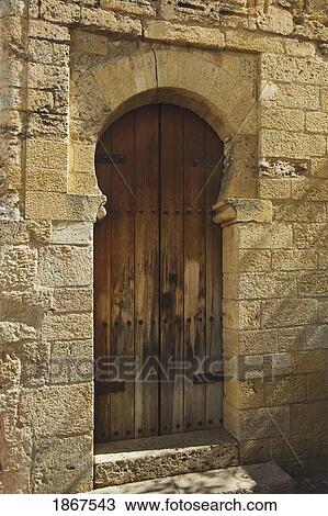Stock Image - Old Weathered Wooden Door With Moorish Stone Arch, Ronda, Spain. Fotosearch