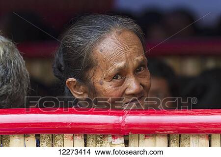 Old woman attending a funeral ceremony at a rante, the ceremonial site for a Torajan funeral, in Sereale, Toraja Land, South Sulawesi, Indonesia View Large Photo Image Picture - Old woman attending a funeral ceremony at a rante, the ceremonial site for a Torajan funeral, in Sereale, Toraja Land, South Sulawesi, Indonesia. Fotosearch