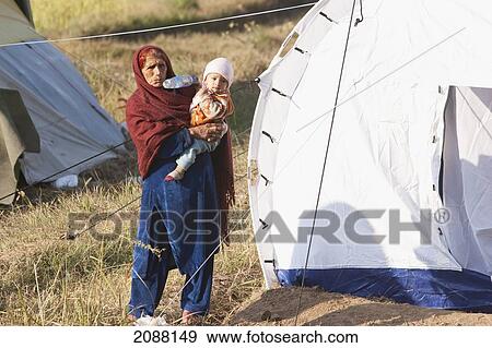 Stock Photo - Old Woman Carrying A Baby In A Relief Camp After The 8 October 2005 Earthquake, Bagh, Azad Kashmir, Pakistan. Fotosearch