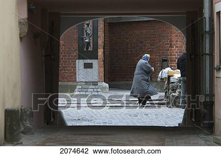 Stock Image - Old Woman In Archway, Riga, Latvia. Fotosearch