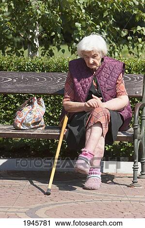 Stock Image - Old woman on a bench in Yuzhen Park, Sofia, Bulgaria. Fotosearch