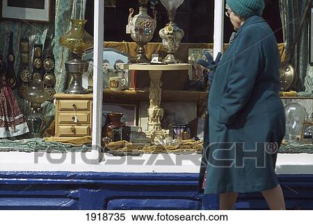Stock Photography - Old Woman Passing Antique Shop Window. Fotosearch
