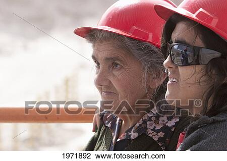 Stock Image - Old Woman With A Safety Hat On A Visit To Chuquicamata, The Largest Open Pit Copper Mine In The World, Antofagasta Region, Chile. Fotosearch