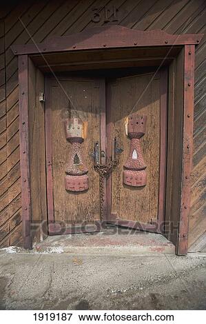 Stock Photo - Old Wooden Medieval Doors On Hotel In Aboriginal Village; Alert Bay, Cormorant Island, British Columbia, Canada. Fotosearch