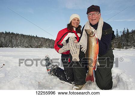 Older fisherman and younger woman showing off a large splake they caught ice fishing; Ontario, Canada View Large Photo Image Stock Photograph - Older fisherman and younger woman showing off a large splake they caught ice fishing; Ontario, Canada. Fotosearch