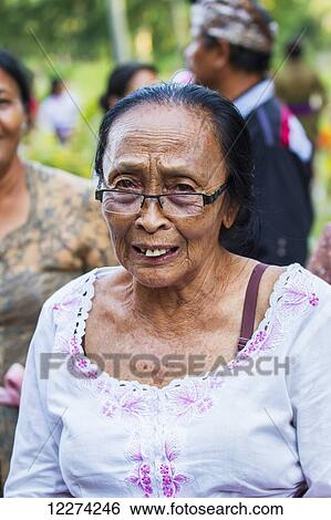 Stock Photograph - Older woman at a Ngaben or Cremation Ceremony, Klungkung, Bali, Indonesia. Fotosearch