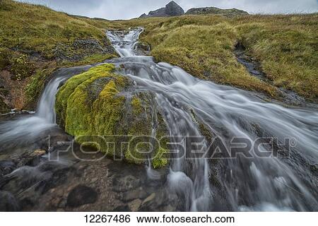 Stock Photograph - One of the numerous streams coming from the mountains in the West Fjords region of Iceland; Iceland. Fotosearch