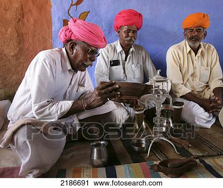 Stock Image - Opium Ceremony In Rural Desert Village Near Jodhpur Rajasthan India. Fotosearch