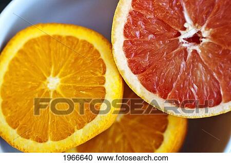 Stock Image - Orange And Pink Grapefruit Halves, Fresh Cut.. Fotosearch