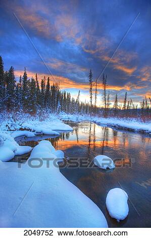 Stock Image - Orange Clouds At Sunset And Little Hazel Creek, Yukon. Fotosearch