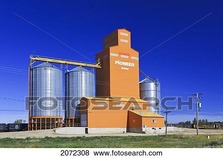 Stock Photo - Orange Grain Elevator And Train Being Loaded On The Canadian Prairie. Morse, Saskatchewan, Canada.. Fotosearch